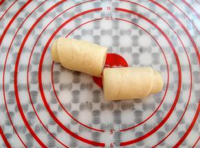 用面团分割板把面团切成2段（不要用刀直接在硅胶垫上切面团）