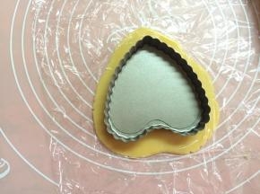 将面团一分二，取一面团直接隔着保鲜膜用擀面杖擀成约3MM厚度、比塔盘稍大一圈的面皮。