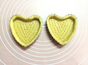 撕开保鲜膜的一面，倒扣在塔盘上，再撕掉保鲜膜另一面，用手按压盘边成型，使塔皮和塔盘帖合（此款塔皮特酥松，按压塔皮时尽量小心别裂了）。用叉子在底部均匀扎上小洞。