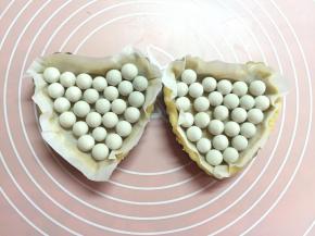 剪一张比派模大一点的油纸，放在派皮上，压上重石。