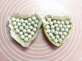 剪一张比派模大一点的油纸，放在派皮上，压上重石。