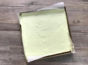 将混合好的面糊倒入铺了油纸的盘内，用刮平稍加刮平，震两下模。