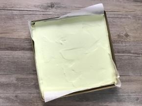 将混合好的面糊倒入铺了油纸的盘内，用刮平稍加刮平，震两下模。