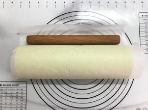 借助擀面杖将蛋糕卷起来，用油纸卷起来放入冰箱冷藏定形30分钟。