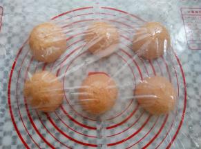 取出面团轻轻排气，平均分成6份，滚圆，盖上保鲜膜静置10分钟