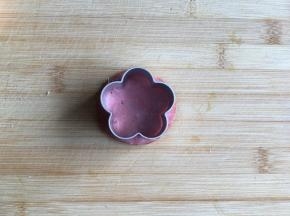 2.	用花朵模具将火腿片压出花朵形状。