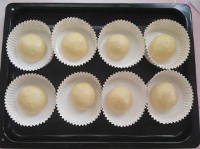 面团再次揉圆放入纸模中（没有纸模就在烤盘上垫油纸直接放油纸上）放烤箱里发酵30分钟