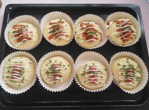 在面团上割一刀，把迷你热狗放上去，挤上适量的沙拉酱，番茄酱和葱花，同时预热烤箱150度