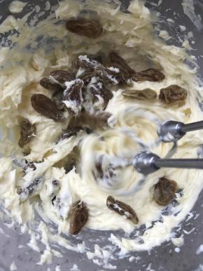 此时准备夹馅，奶油奶酪提前软化，加入糖粉打喜欢顺滑，然后分次加入淡奶油，，搅打至融合细腻，再加入软的葡萄干。