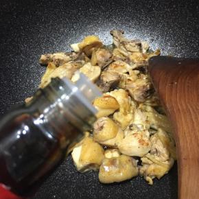 炒至鸡块颜色变白，水分收干，淋入酱油，加入一小块冰糖。