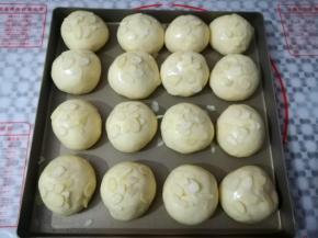 面团发酵到2倍大小，取出在面团上刷一层薄薄的蛋液，撒上适量的杏仁片，同时预热烤箱上火130度，下火170度