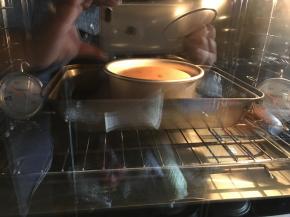 模具里的面糊如果表面不平整，疙疙瘩瘩凹凸不平，在桌面上，推动模具盆前后移动，晃悠它，让它表面平整，然后提起来震摔一下，摔出气泡。烤箱预热135度，观察温度计到预热温度时，送进模具，避免表面开裂，烤架上放一个烤盘，也可以防止底热过热，烤50分钟。