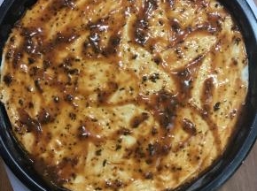 面团擀一下，平铺盘底，用餐叉扎几个孔，涂上披萨酱