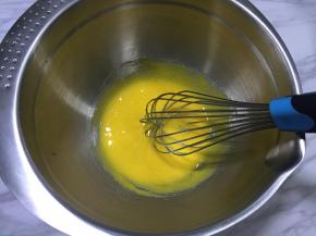 蛋糕烤制的时候就可以动手制作豆乳，蛋黄中加入细砂糖，用手动打蛋器搅拌均匀。
