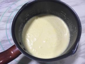 将豆浆蛋黄糊倒入奶锅，小火加热，全程需不停搅拌。