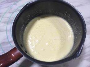 将豆浆蛋黄糊倒入奶锅，小火加热，全程需不停搅拌。