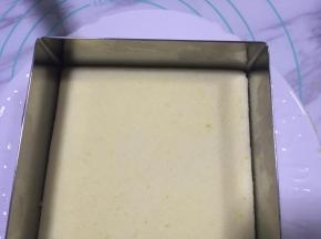 因为使用的是慕斯圈，脱模比较方便，可以直接在蛋糕盒垫片或盘子上制作。将慕斯圈放在盘子上，把之前切割好的蛋糕片放入模具中。