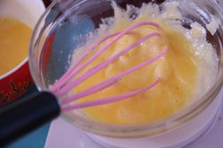 然后分三次加入全蛋液，用手动打蛋器搅匀，每次完全搅匀后，再加入下一次。