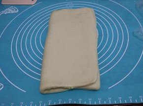 把右边空出的面团折向中间，左边的面团也折向中间，折成一个小的长方形。