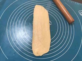  取一个卷好的面卷再次擀成长舌状，拍掉气泡