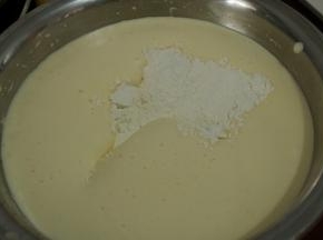 6一次性加入过筛的低筋面粉，用刮刀由底部往上翻拌。