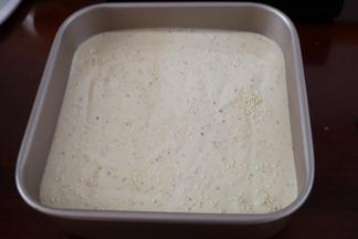 把蛋糕糊倒入模具（法焙客正方形活底蛋糕模），表面撒芝麻。