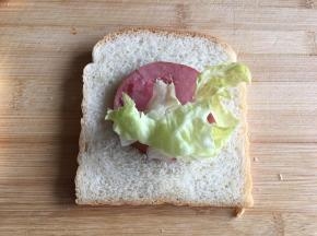 2.	将土司上放上生菜和火腿片。