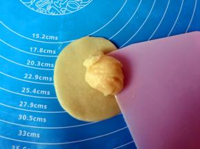 取一个水油皮，擀成圆片，包入油酥。（油酥有点软，没关系，借助刮板把油酥铲起来放进油皮就好了）