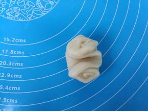 取过一个卷，两头向中间压下，整理成圆形。烤箱预热上下火190度。