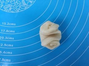 取过一个卷，两头向中间压下，整理成圆形。烤箱预热上下火190度。