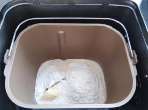 把配方中除芝麻外，所有材料按照先液体再粉末的顺序放入面包桶内，酵母放面粉上，黄油放一侧，选择和面程序，时间15分