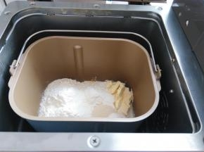 将配方中所有材料按照先粉末在液体的顺序放入面包桶内，酵母放面粉上，黄油放一侧，启动和面程序，时间设定28分钟