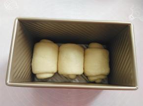 把面团放入土司盒内，盖上保鲜膜，放烤箱内发酵