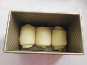 把面团放入土司盒内，盖上保鲜膜，放烤箱内发酵