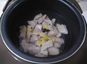 电饭煲里放入没过肉块的水，再放入生姜和八角，煮1小时