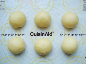 把面团放在垫子上，平均分成6份，排气团成光滑的小圆球。