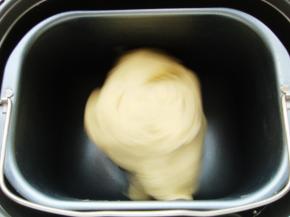 把面包桶放入面包机内，启动和面程序。开始和面。（不用纠结手套膜，能拉出厚膜即可）