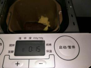 面包机和面10分钟后暂停面包机，静置5分钟，然后开启和面程序和面15分钟。此时加入黄油和面。