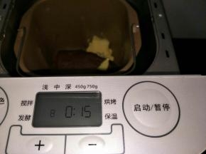 面包机和面10分钟后暂停面包机，静置5分钟，然后开启和面程序和面15分钟。此时加入黄油和面。