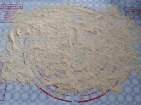 在揉面垫上撒上黄豆面，尽量撒宽一点
