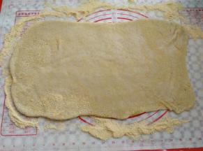 面团有余温的时候放到揉面垫上，把面团擀成一张大饼皮