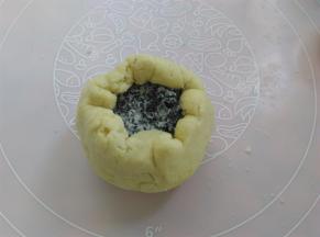 面团向上收口，为了避免沾模具，面团上滚一层薄薄的手粉