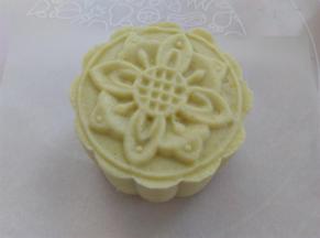 轻推模具，把糯米团推到油纸上，如果糯米团有点软，可以用手扶一下糯米团的腰部帮助脱模