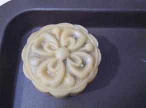 月饼模具倒扣在烤盘上，向下按压，轻轻提起模具