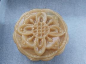 把月饼球放入50克模具里，月饼模具倒扣在油纸上，向下按压，轻轻提起模具，清晰的花纹就出来了