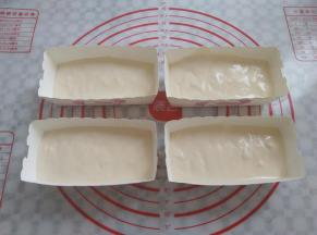 蛋糕糊倒入小蛋糕纸模中，用牙签在蛋糕糊中划几下，有助于去掉蛋糕糊中的大气泡