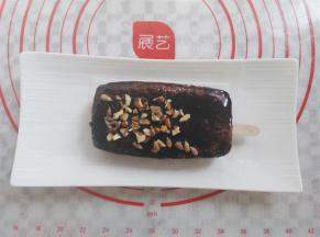 在裹好酱的蛋糕上撒上适量的坚果粒，为了方便拿，我在蛋糕胚下面垫了一张小的油纸