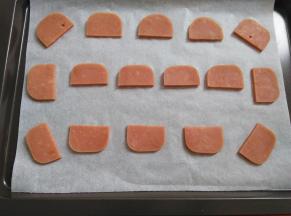 火腿肠摆放到烤盘里，建议铺上油纸，烤的过程中会有汤汁溢出来