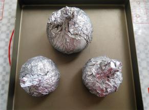 给洋葱包上锡纸，尽量把洋葱包紧一点，放到烤盘里，同时预热烤箱180度5分钟