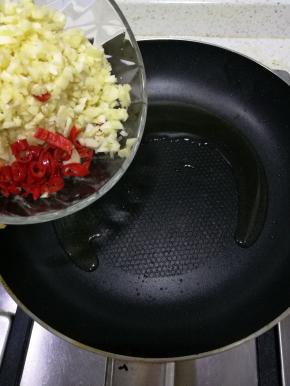 然后我们准备蒜蓉酱，把两头蒜切末（尽量切小点，好吃），朝天椒两个切碎，锅中放油爆香